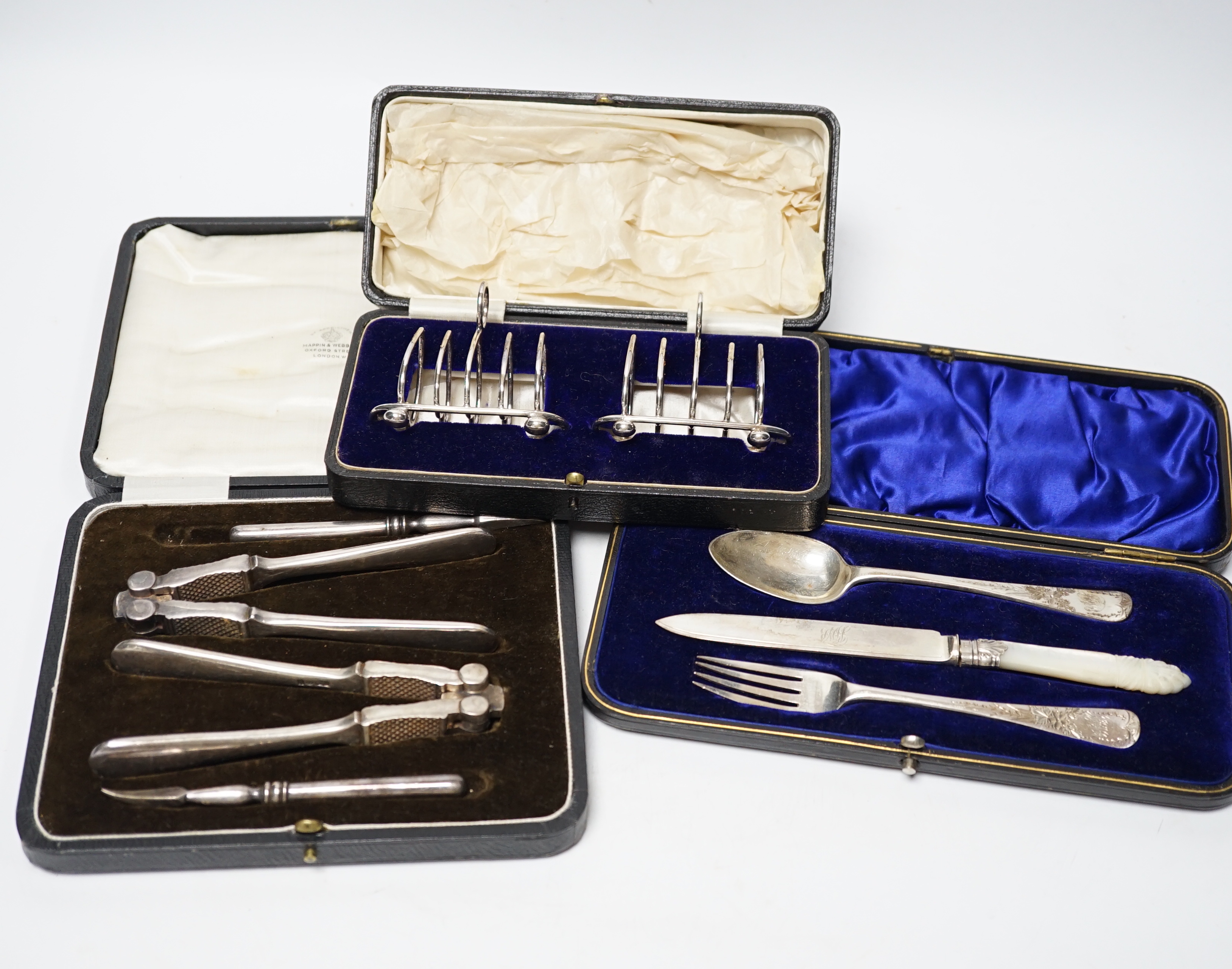 Thirteen assorted cased silver sets, including two sets of six handled tea knives, Leicester and Pudsey replica spoons, two matched sets of napkin rings, single spoon, christening trio, two sets of teaspoons, pair of toa